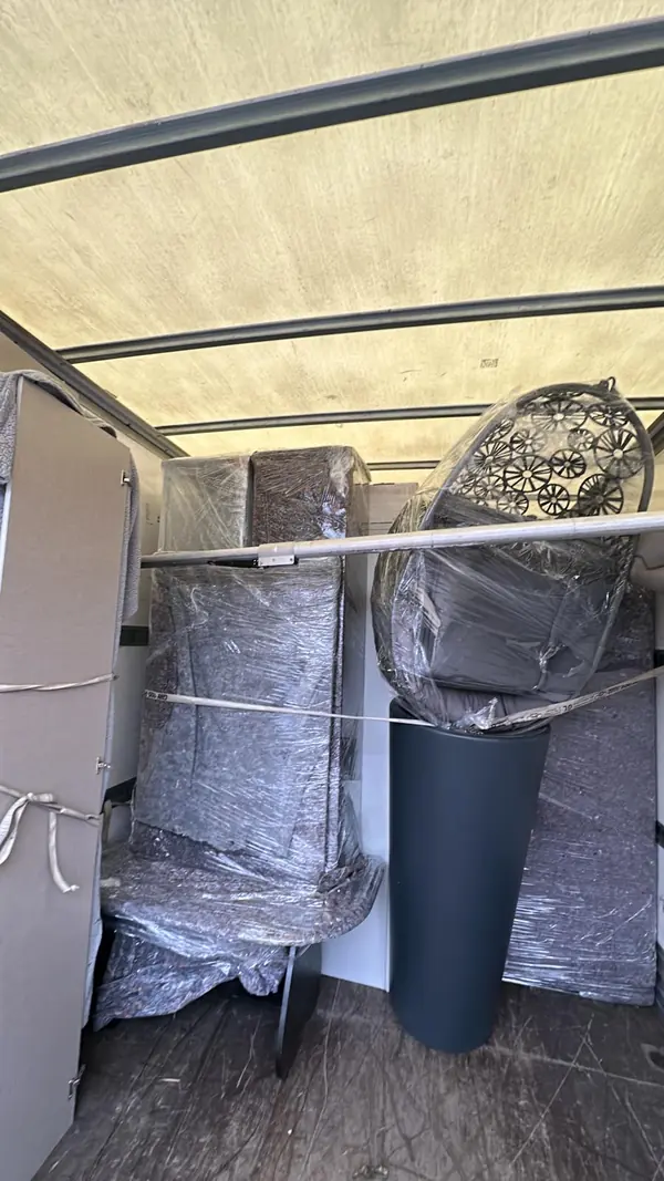 Kühlschrank und Möbel in Schutzdecken verpackt im Laderaum