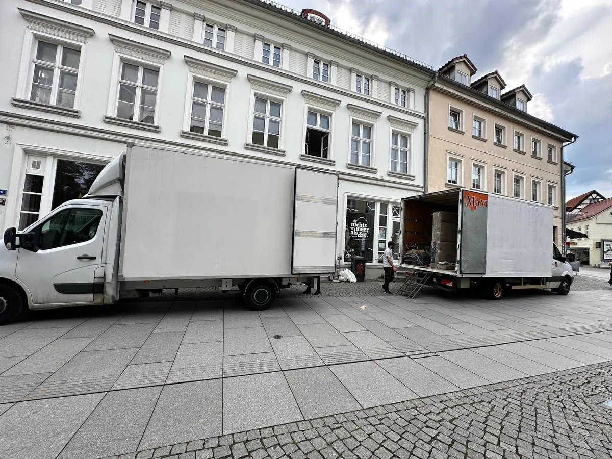 Zwei Umzugswagen von Vortex beim Beladen vor einem Altbau in der Altstadt